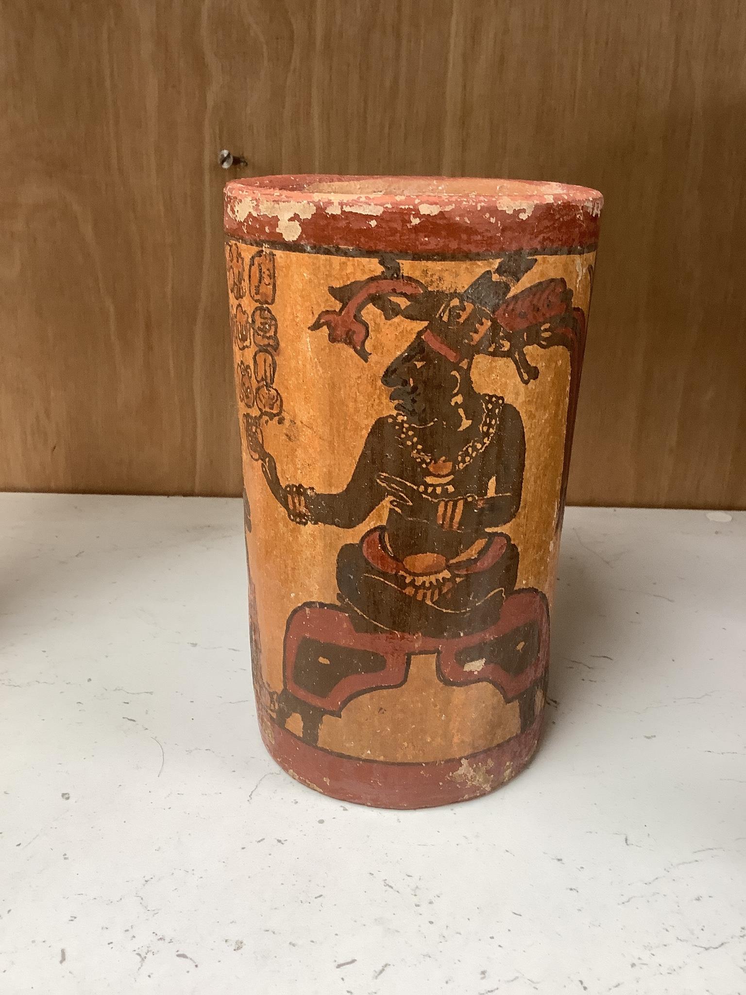 A Mayan pigment painted terracotta cylindrical vessel, possibly 7th-9th century AD., 17.2cm high, under a glass dome with revolving wood stand, total height 26cm